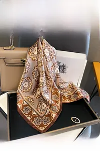 Dettaglio della texture di un foulard in seta con stampa paisley su sfondo in pelle