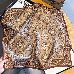 Foulard quadrato in seta vintage con motivi paisley e mandala marroni su tavolo