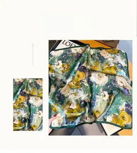 Vue détaillée d'un foulard en soie verte avec motifs floraux abstraits et bords roulés