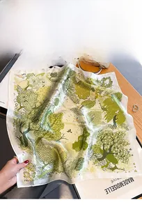 Detail of forest theme silk scarf featuring trees and deer prints on premium fabric