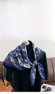 Detailed close-up of retro floral print silk scarf featuring elegant blue and white patterns