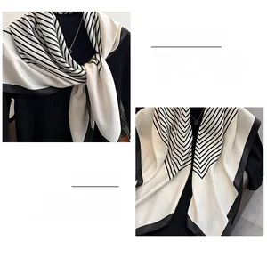 Detail showing the exquisite overlock stitching and satin texture of a geometric silk scarf