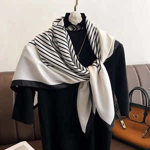 Elegant black and white twill silk scarf with stripes on a black mannequin display