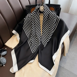 Elegant 90cm black and white striped silk square scarf on a beige sweater