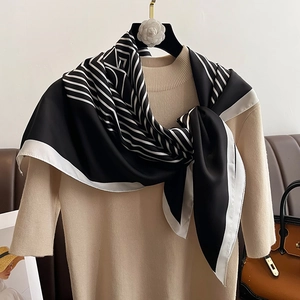 Elegant geometric diagonal stripe silk scarf styled on beige knitwear with gold accent