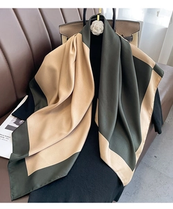 Detail of color-block silk scarf with dark green and gold satin geometric pattern