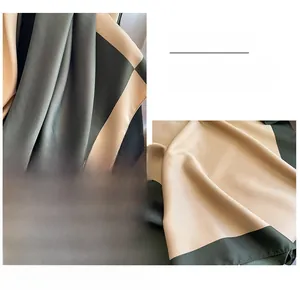 Detail of color-block satin scarf with fine stitching and silk-like glossy texture