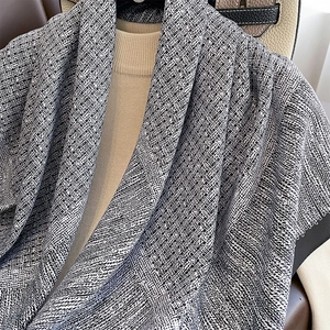 Klassisches schwarz-weißes Seidentuch kombiniert mit beigem Strickpullover und Ledertasche