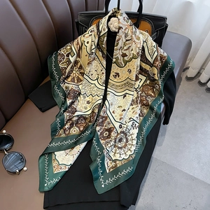 Detail of silk-feel scarf with bohemian patterns draped on a handbag and suit