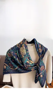 Detailed close-up of a vintage floral twill silk scarf with intricate patterns on a hanger