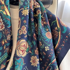 Vintage floral print silk scarf in navy blue draped over a handbag and knit sweater