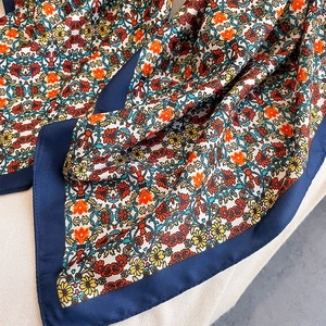 Floral twill silk scarf with vintage orange patterns and navy blue borders
