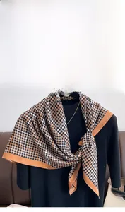 Détail d'une écharpe en sergé de soie à motif pied-de-poule avec bordure marron sur mannequin