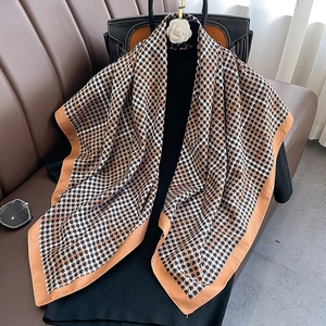 Carré de soie chic à motif pied-de-poule et bordure marron sur une tenue noire