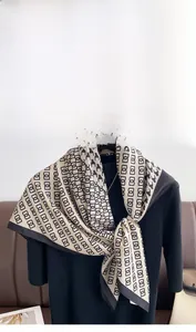Detail of elegant houndstooth silk scarf tied on mannequin with a camellia brooch