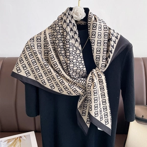 Classic houndstooth and chain pattern silk scarf styled on a model over a leather background