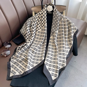 Detail of elegant houndstooth and chain pattern silk scarf styled on a mannequin