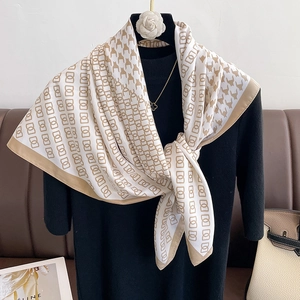 Detail of houndstooth and geometric pattern silk scarf draped on a mannequin