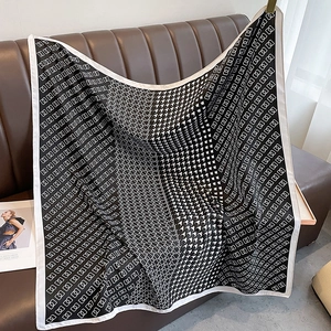 Close-up of houndstooth square scarf with geometric patterns on a leather sofa