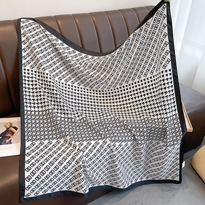 Detail of classic black and white houndstooth silk scarf with geometric chain pattern