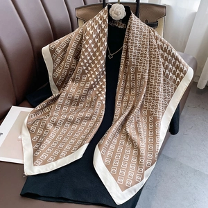 Detail of caramel houndstooth silk scarf showing elegant geometric patterns and soft texture