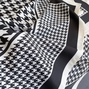 Classic houndstooth twill silk scarf with black borders and elegant draped texture
