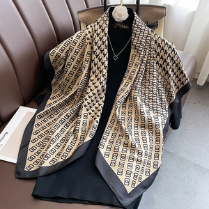 Detail of elegant houndstooth silk scarf with geometric rings on a leather background