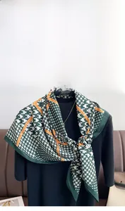 Detail of green and white houndstooth silk scarf with orange Fashion Modern text