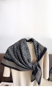 Detailed view of vintage geometric floral silk scarf tied over a beige turtleneck sweater