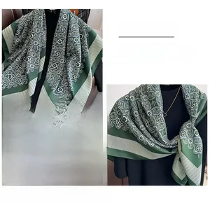 Detail of vintage floral pattern and edge stitching on a dark green silk scarf