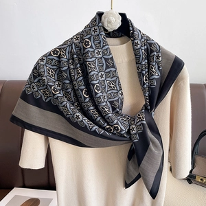 Detail view of vintage geometric silk scarf draped on neck over cream knit sweater