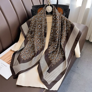 Detailed view of vintage geometric silk scarf styled with a black leather designer handbag