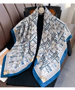 Detail of twill silk scarf with blue geometric patterns and printed lettering motifs