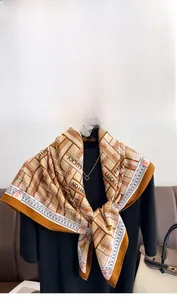 Detailed close-up of a twill silk scarf with geometric patterns and caramel color tones