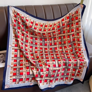 Close-up of geometric pattern silk scarf with Lucky lettering on a leather background