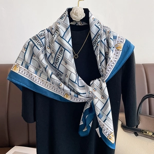 Detail view of a navy blue geometric silk scarf styled on a black collar mannequin