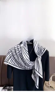 Detail of classic black and white striped silk twill scarf draped on a mannequin model