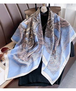 Detail view of a 90cm silk scarf with sky blue architecture print and rolled edges