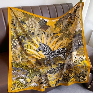 Floral zebra print large silk scarf with golden yellow border draped on leather furniture