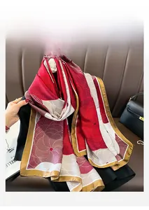 Detail of elegant silk scarf with red and gold spiral patterns draped on a black dress
