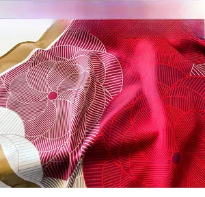Detailed view of red and white floral silk scarf with gold stitched edges and satin texture