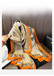 Détail d'un foulard en soie champagne avec bordures orange et motifs de papillons élégants