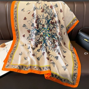 Détail d'un châle en soie avec motifs de fleurs, papillons et bordure orange