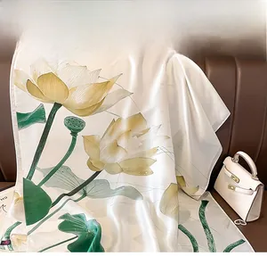 Detail of silk scarf showing lotus floral patterns draped on a leather surface