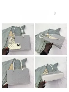 Detail view of the embossed tote bag with thick bottom and stylish printed scarf accessory
