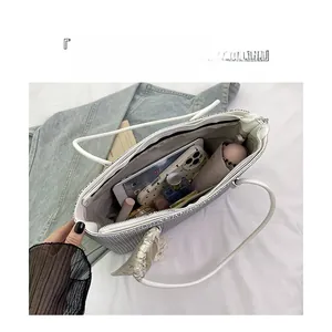 Interior of silver sequin tote bag showing organized compartments and daily essentials