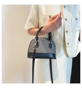 Detail of grey fabric and black leather contrast on retro crossbody shell bag