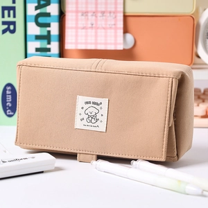 Detail of beige canvas puppy pencil case with cute embroidery in a desk setup