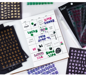 Gros plan d'autocollants alphabet 3D colorés sur une page de carnet créatif