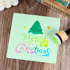 Christmas DIY sponge stamper with wooden handle and a green Merry Christmas card